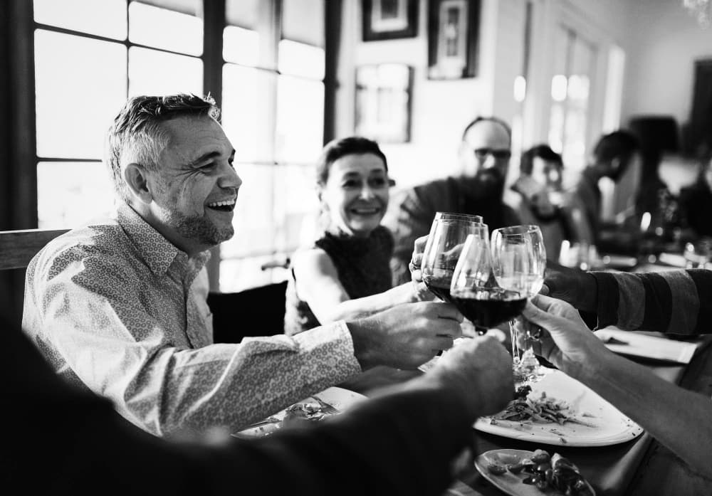 Group of friends toasting and celebrating at a table full of food.