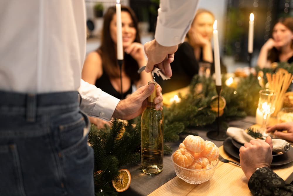 Server opening a bottle of wine tableside for guests celebrating a special occasion